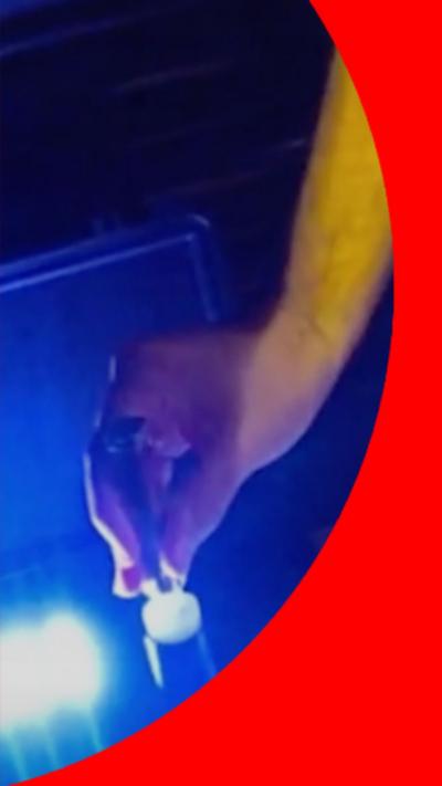 A police officer testing a vape in specialist equipment to determine if it has been spiked or not.
