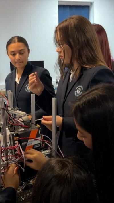 Two teenage girls in school uniform with technical equipment