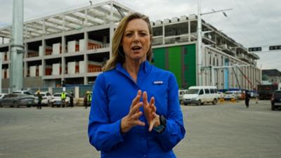 BBC correspondent Laura Bicker wearing a blue shirt standing outside a construction site
