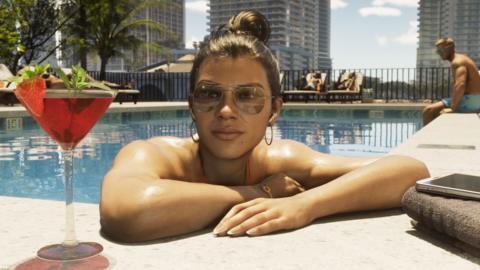 Screenshot from GTA 6 shows Lucia resting her elbows on the corner of a swimming pool next to what appears to be a rooftop hotel bar. A cocktail glass is on her right and a mobile phone on top of a folded towel is on her left.