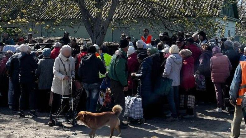 People in Oleshky gather for food delivery