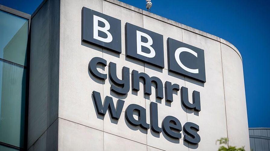 A view of the BBC Cymru Wales sign on the side of the Central Square studios building in Cardiff. Cymru Wales is in small letters, next to the BBC which is in its traditional block logo.