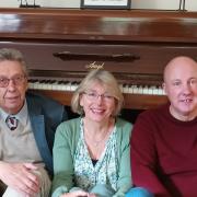 Poets Philip Hutton (left) and Anita John (centre) accompanied by Brian Davidson (right) on the piano